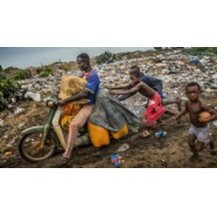 A man crosses the border between Benin and Togo with his motorcycle laden with gasoline. He has over 200 litres of fuel and is helped by a group of children at the Hila-Condji border post in Aného. Photo: Antonio Aragón Renuncio.