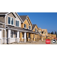 Homes in a row along a street being built with Wells Fargo and U.S. Conference of Mayors logos in the right corner.