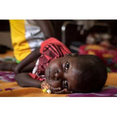 UNICEF/UNI451574/LeMoyne
A child rests on a bed in the nutrition clinic at L’hôpital de Bossangoa in Bossangoa, Central African Republic.
