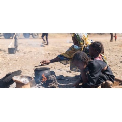 © UNOCHA/Ala Kheir An internally displaced woman cooks in an open space in the El Ban Gadeed settlement in Sudan.