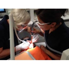 @ WHO / Faith Vorting
Dentist and dental assistant cleaning the teeth of a young girl in a clinic.