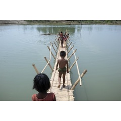 � UNICEF/UN0203395/Sokol
Rohingya children from Myanmar play on a bamboo bridge crossing a shallow body of water at high tide in Shamlapur refugee camp, Cox�s Bazar District, Bangladesh.