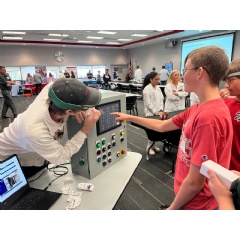 A Honda associate at the East Liberty Plant shows a River Valley School student how to interact with a manufacturing control panel during MFG Day.