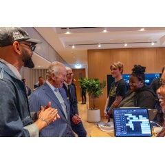 From left to right: Apple Music’s Prophet Guillory, His Majesty The King, and Tim Cook celebrate the launch of the Apple x King’s Trust Creative Labs at Apple Music Hall in London.