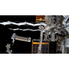 NASA astronaut Josh Cassada holds a roll-out solar array as he rides the Canadarm2 robotic arm during a spacewalk in support of the Expedition 68 mission aboard the International Space Station on Dec. 3, 2022. Credit: NASA