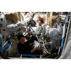 NASA astronauts Anne McClain (bottom) and Nichole Ayers (top), both Expedition 73 Flight Engineers, checkout spacesuit hardware in the Quest airlock and review procedures for a May 1 spacewalk. Credit: NASA Johnson Space Center