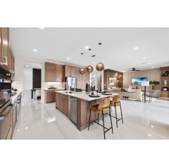 Luxuriously designed open-plan kitchen and living area in a GL Homes’ RiverCreek Cascade model home, embodying the award-winning designs that earned the 2024 Superior Home Awards from Lee County Builder Industry Association’s Parade of Homes.